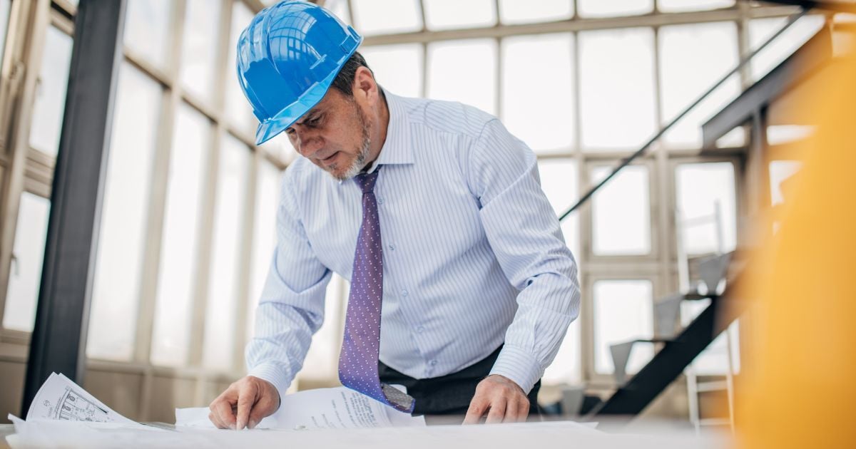 Construction company director reviewing finance options with an adviser on site