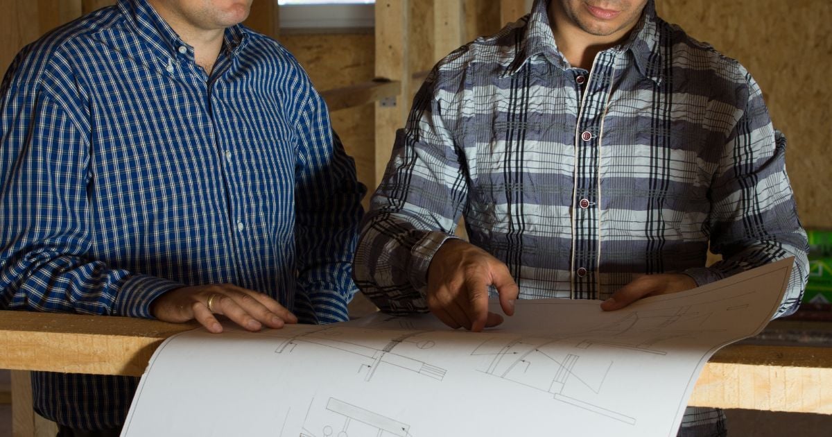 Engineers reviewing design drawings on a UK construction site, illustrating R&D tax relief for construction companies